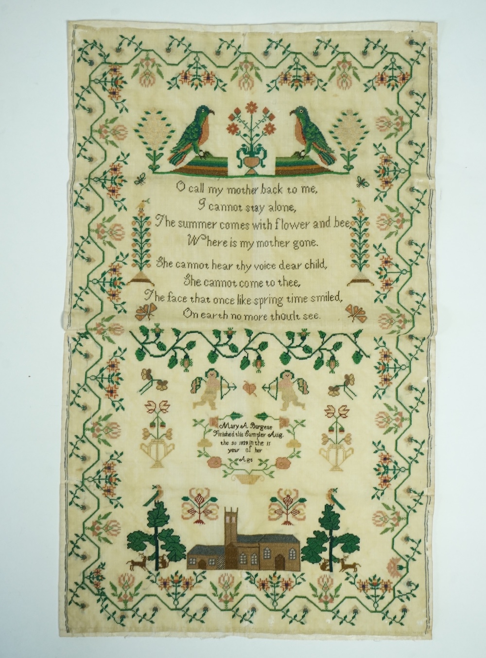 A unusual early 19th century finely worked colourful unframed sampler. Dated 30th August 1839 by Mary A. Burgess, aged 15 years, worked in a cartouche within a garland of flowers.The top with large spot motifs of parrots
